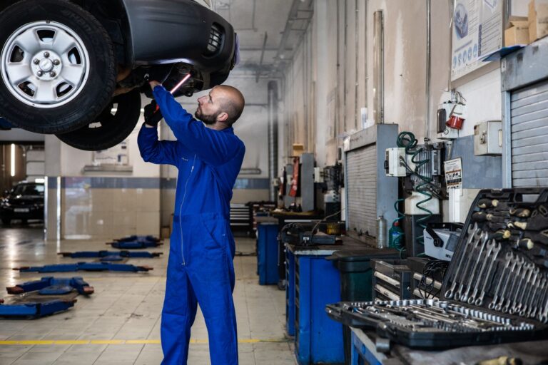 Майстер оглядає піднятий автомобіль у сервісі перед діагностикою